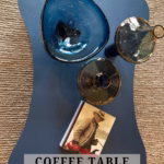 Oddly shaped coffee table with vases and bowls on it