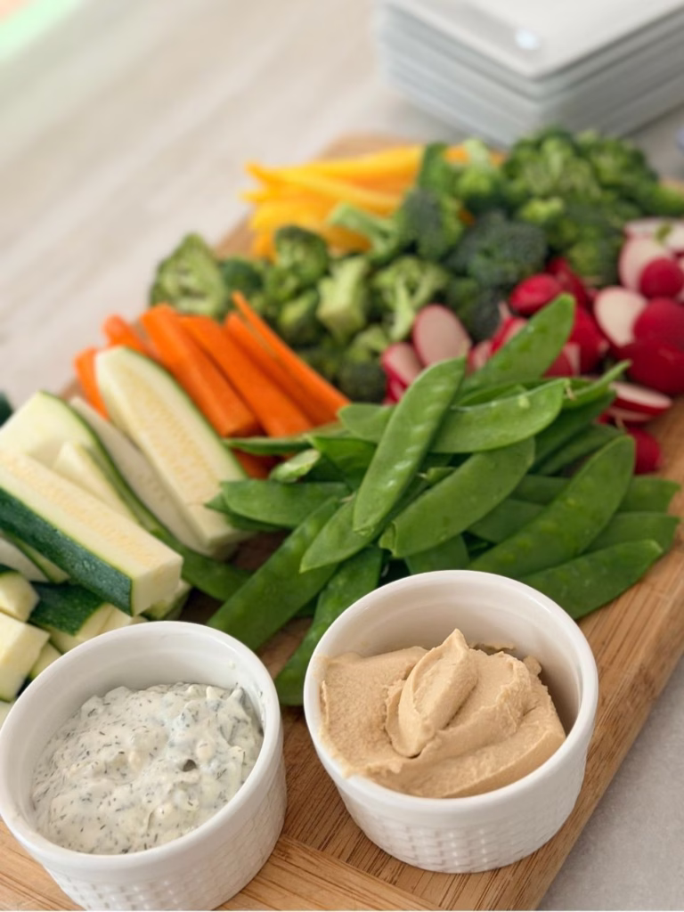 a vegetable platter with hummus and tzatziki