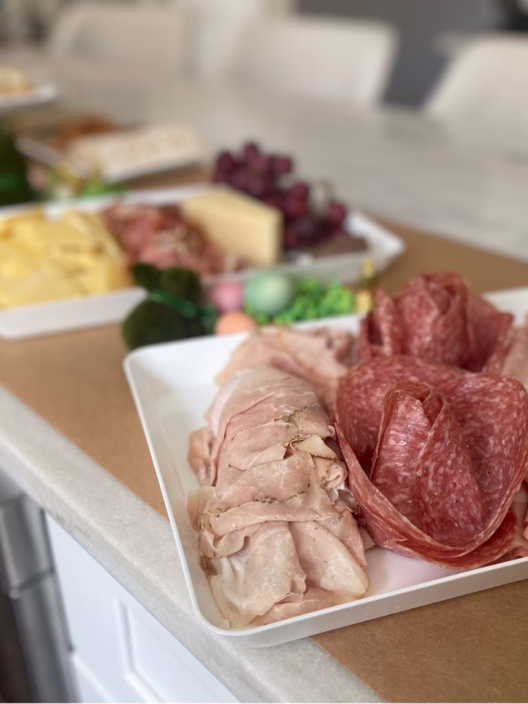 Kraft paper with white platters on it that have meats on them.
